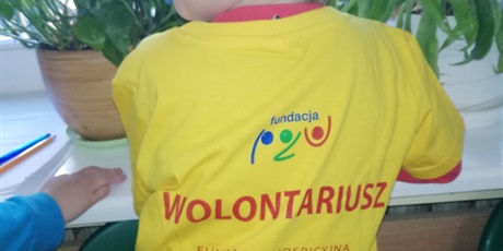 Powiększ grafikę: Na zdjęciu chłopiec w żółtej koszulce wolontariusza.