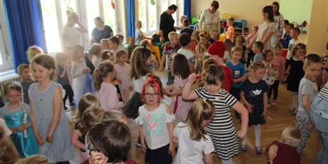 Powiększ grafikę: Na zdjęciu grupa dzieci tańczących w sali gimnastycznej podczas zabawy tanecznej.