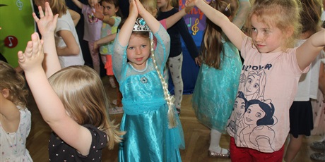 Powiększ grafikę: Na zdjęciu grupa dzieci tańczących w sali gimnastycznej podczas zabawy tanecznej.