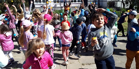 Powiększ grafikę: Na zdjęciu grupa dzieci podczas zabaw na przedszkolnym placu zabaw podczas uroczystości i zabaw z okazji Dnia Dziecka