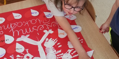 Powiększ grafikę: Plakat orła białego namalowany przez dzieci farbkami z sercami biało czerwonymi oraz odciśnietymi dłońmi.