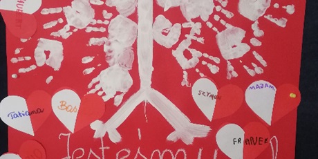 Powiększ grafikę: Plakat orła białego namalowany przez dzieci farbkami z sercami biało czerwonymi oraz odciśnietymi dłońmi.
