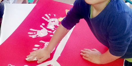 Powiększ grafikę: Na zdjęciu dziecko odciskające dłoń na palkacie z orłem białym