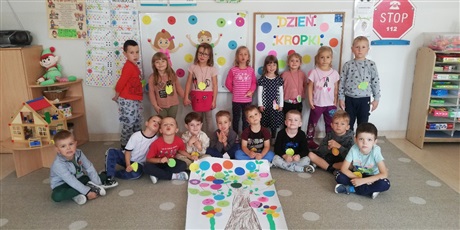 Powiększ grafikę: Na zdjęciu grupa dzieci w wieku przedszkolnymnW tle kolorowe kropki.