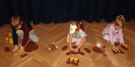 Powiększ grafikę: Na zdjęciu dziecko w wieku przedszkolnym układające puzle  postaci papierowych misi 