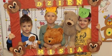 Powiększ grafikę: Na zdjęciu dzieci w wieku przedszkolnym w ramce z papieru z misiami i opaskami na głowie z misiami