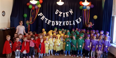 Powiększ grafikę: Na zdjęciu  dzieci w wieku przedszkolnym w kolorowych strojach skrzatów podczas obchodów dnia przedszkolaka.