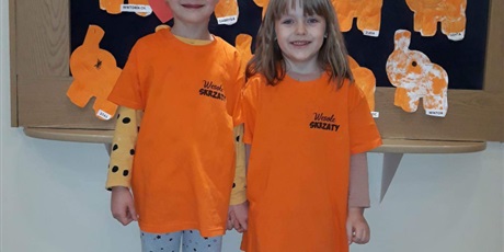 Powiększ grafikę: Na zdjęciu grupa dzieci w koszulkach koloru pomarańczowego.