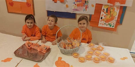 Powiększ grafikę: Na zdjęciu dzieci w wieku przedszkolnym w koszulkach koloru pomarańczowego podczas kwesty.
