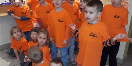 Powiększ grafikę: Na zdjęciu grupa dzieci w koszulkach koloru pomarańczowego.