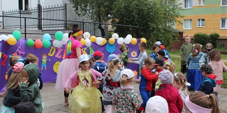 Powiększ grafikę: Na zdjęciu grupa dzieci w wieku przedszkolnym w kolorowych strojach podczas zabaw z okazji dnia dziecka