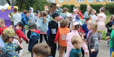 Powiększ grafikę: Na zdjęciu grupa dzieci w wieku przedszkolnym w kolorowych strojach podczas zabaw z okazji dnia dziecka
