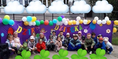 Powiększ grafikę: Na  zdjęciu kolorowa dekoracja z napisem dzień dziecka oraz grupa dzieci w wieku przedszkolnym .