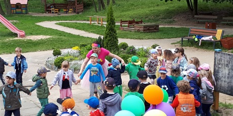 Powiększ grafikę: Na zdjęciu grupa dzieci w wieku przedszkolnym w kolorowych strojach podczas zabaw z okazji dnia dziecka.