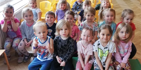 Powiększ grafikę: Na zdjęciu grupa dzieci w wieku przedszkolnym na slai gimnastycznej pdczas  oglądania muzycznego koncertu