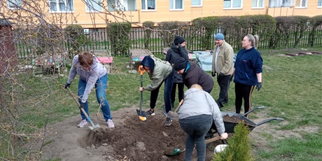 Powiększ grafikę: Na zdjęciu praca w ogrodzie przedszkolym oraz grupa ludzi kopiących łopatami ziemię.