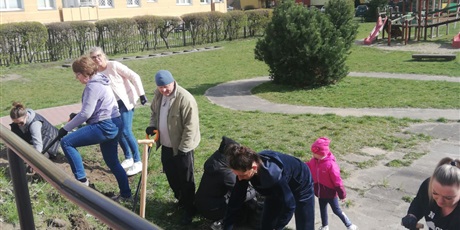 Powiększ grafikę: Na zdjęciu praca w ogrodzie przedszkolym oraz grupa ludzi kopiących łopatami ziemię.