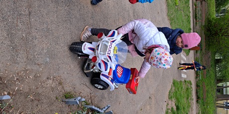 Powiększ grafikę: Zabawy dzieci w wieku przedszkolnym na policyjnym motorku zabawce.