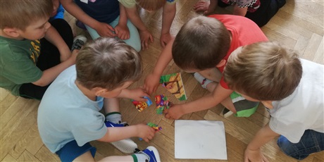 Powiększ grafikę: Na zdjęciu dzieci w wieku przedszkolnym układające puzle..