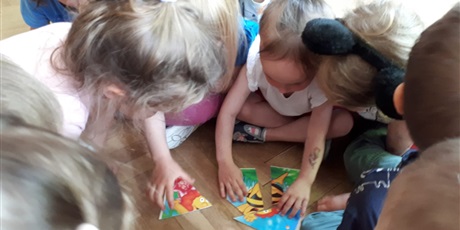 Powiększ grafikę: Na zdjęciu dzieci w wieku przedszkolnym układające puzle.
