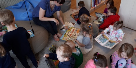 Powiększ grafikę: Dzieci oglądają książki z kolorowymi ilustracjami.