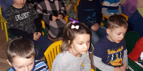 Powiększ grafikę: Na zdjęciu grupa dzieci w ieku przedszkolnym oglądających przedtawienie w sali gim.nastycznej.