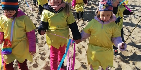 Powiększ grafikę: Na zdjęciu dzieci w żółtych strojach na plaży witający wiosnę