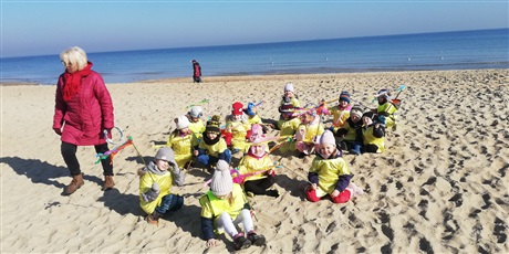 Powiększ grafikę: Na zdjęciu dzieci w żółtych strojach na plaży nad morzem witający wiosnę.
