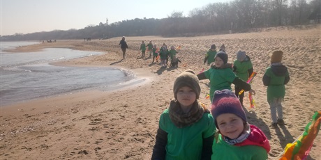 Powiększ grafikę: Na zdjęciu dzieci w wieku przedszkolnym w kolorowych strojach na plaży witające wiosnę.