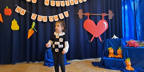 Powiększ grafikę: Na zdjęciu dziewczynka w wieku przedszkolnym podczas  występu w konkursie recytatorskim