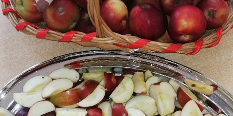 Powiększ grafikę: Na zdjęciu kosz wiklinowy z jabłkami i taca srebrna z pokrojonymi jabłkami.ta
