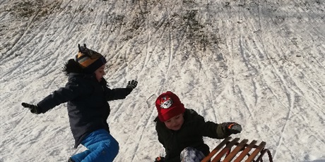 Powiększ grafikę: Na zdjęciu dzieci zjeżdżające na sankach ze śniegowej górki