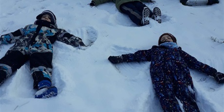 Powiększ grafikę: Na zdjęciu dzieci leżące na śniegu.