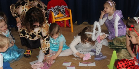 Powiększ grafikę: Na zdjęciu dzieci w wieku przedszkolnym podczas  konkursu układające pączki paierowe