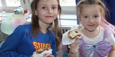 Powiększ grafikę: Na zdjęciu dzieci w wieku przedszkolnym jedzące pączki.