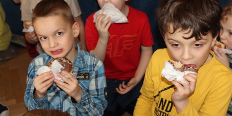 Powiększ grafikę: Dzieci w wieku przedszkolnym jedzące pączka.