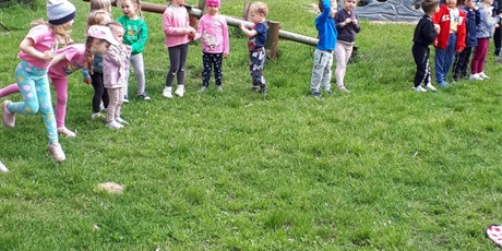 Powiększ grafikę: Na zdjęciu grupa dzieci stojących na przedszkolnym placu zabaw.