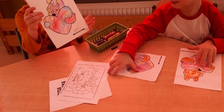 Powiększ grafikę: Na zdjęciu dzieci w wieku przedszkolnym podczas zabaw walentynkowych kolorujące obrazek misia z serduszkiem