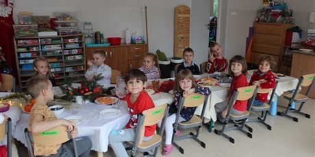 Powiększ grafikę: Na zdjęciu dzieci w wieku przedszkolnym przy wigilijnym stole