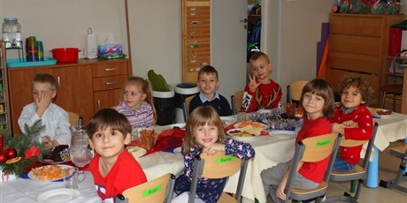 Powiększ grafikę: Na zdjęciu dzieci w wieku przedszkolnym przy wigilijnym stole