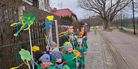 Powiększ grafikę: Na zdjęciu grupa dzieci w wieku przedszkolnym w strojach zielonych z kwiatkami  witająca wiosnę