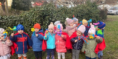 Powiększ grafikę: Na zdjęciu grupa dzieci w wieku przedszkolnym w strojach czerwonych z kwiatkami  witająca wiosnę.