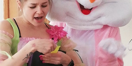 Powiększ grafikę: Na zdjęciu różowo biały zając i kobieta przebrana za panią wiosnę.