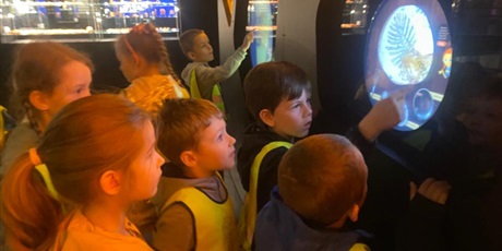 Powiększ grafikę: Grupa dzieci w wieku przedszkolnym w żółtych kamizelkach podczas wizyty w Muzeum Bursztynu.