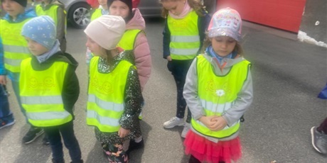 Powiększ grafikę: Na zdjęciu grupa dzieci w ieku przedszkolnym w odblaskowych kamizelkach.