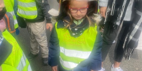 Powiększ grafikę: Na zdjęciu grupa dzieci w wieku przedszkolnym przed wozem strażackim  i dziewczynka w kasku .