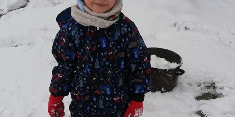Powiększ grafikę: Chłopiec podczas zimowych zabaw na przedszkolnym placu zabaw