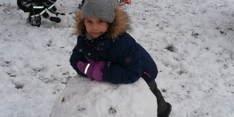 Powiększ grafikę: Dzieci podczas zabaw na śniegu toczący kulę śnieżną