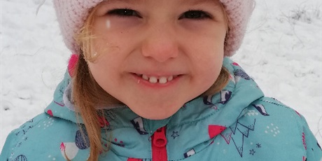Powiększ grafikę: Uśmiechnięta dziewczynka podczas zabaw zimowych na przed
