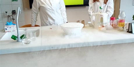Powiększ grafikę: Na zdjęciu nauczycielka i uczennica podczas  pokazu eksperymentu z suchym lodem.
